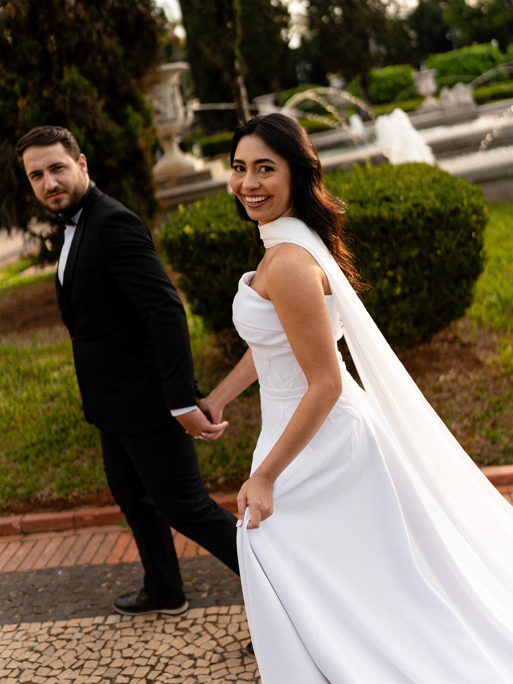 Casal de noivos caminhando em um jardim